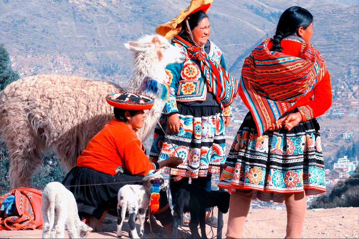 women with typical costumes of the Peruvian Andes and their llamas