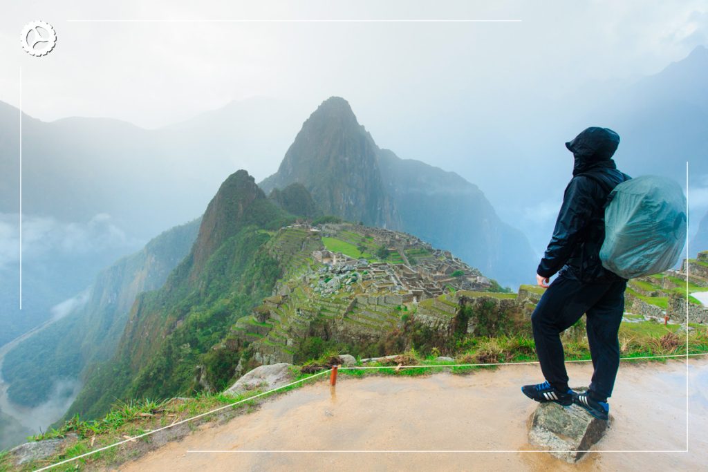 Tourist proudly overlooking the imposing surroundings of Machu Picchu