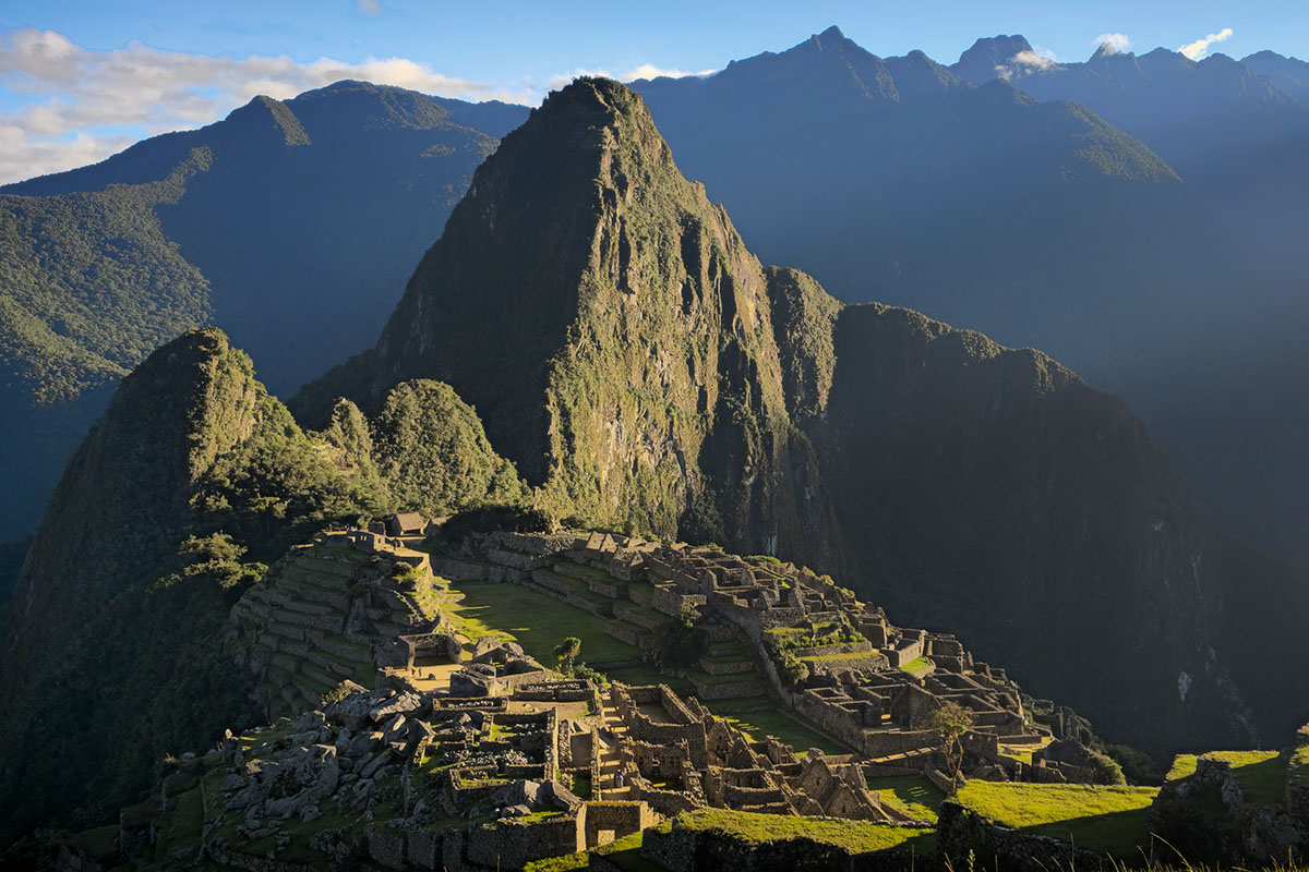 Primeros rayos del sol sobre la ciudadela Inca de Machu Picchu, una visita obligatoria en el itinerario de viaje en Perú