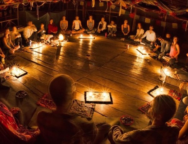 Círculo de ceremonia de ayahuasca dentro de una maloca con velas | Conde Travel