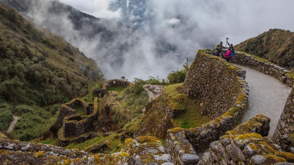 Hikers on ancient stone trail in Machu Picchu, Peru