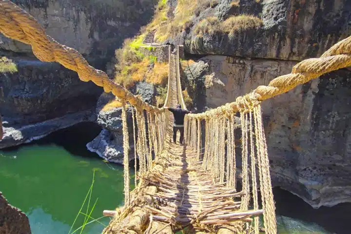 Puente Q’eswachaka: El Último Puente Inca de Perú 3 Travelers crossing the traditional Q’eswachaka Inca rope bridge in Peru