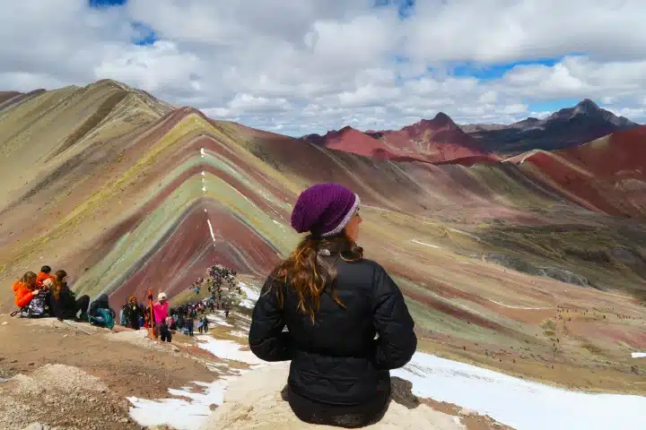 ¿Cuántos días necesitas en Cusco para disfrutar tu viaje? 2 Traveler admiring the colorful peaks of Rainbow Mountain near Cusco, Peru.