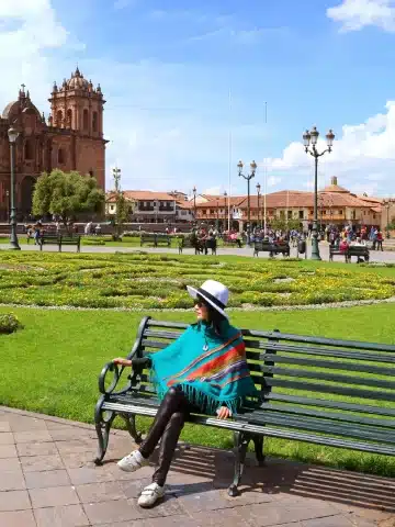 Valle Sagrado vs Cusco: ¿Cuál es mejor para tu viaje a Perú? 4 Traveler relaxing in Cusco’s Plaza de Armas, the historic heart of the former Inca capital.