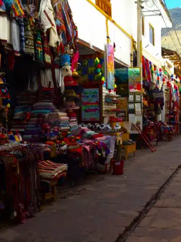 Valle Sagrado vs Cusco: ¿Cuál es mejor para tu viaje a Perú? 2 Artisan stalls selling traditional textiles and souvenirs in Pisac.