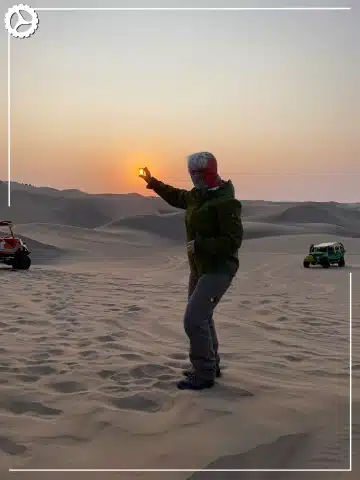 Paracas, Ballestas Islands, Huacachina & Nazca: The Perfect 2-Day Peru Itinerary 6 Traveler enjoying sunset over the Huacachina sand dunes in Peru