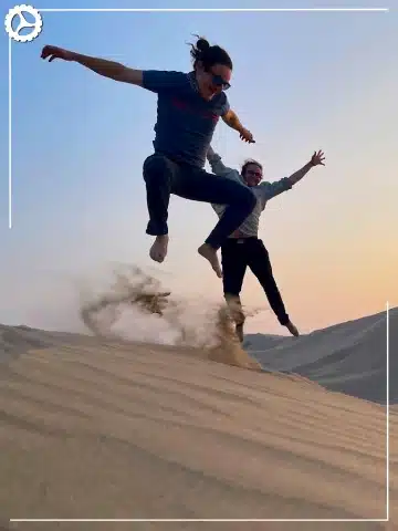 Paracas, Ballestas Islands, Huacachina & Nazca: The Perfect 2-Day Peru Itinerary 5 Travelers enjoying sandboarding on the dunes of Huacachina Oasis