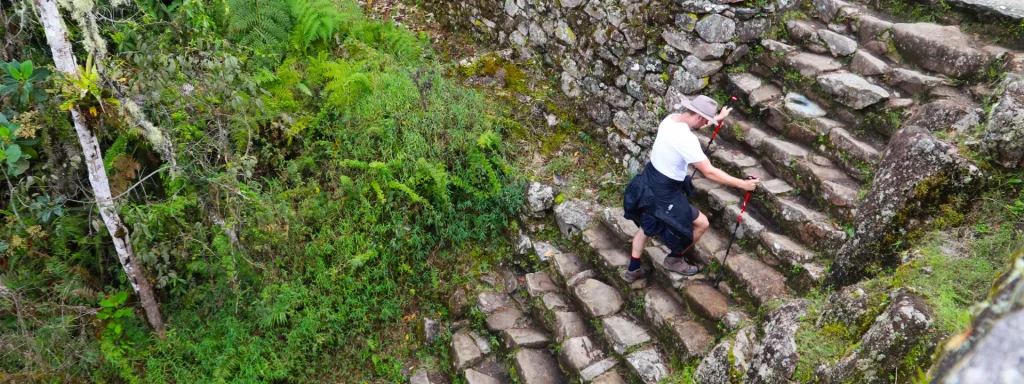 Inca Trail difficulty with a hiker climbing stone steps in Peru