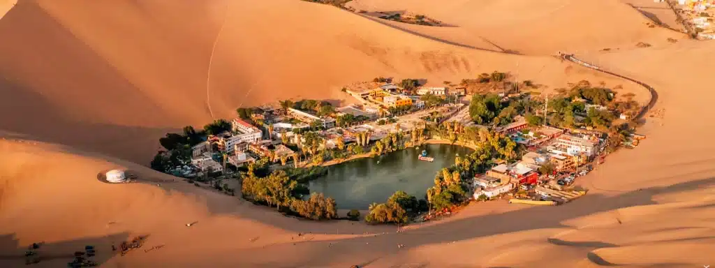 Huacachina Peru oasis surrounded by desert dunes