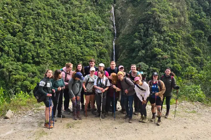 Salkantay Mountain: History, Meaning and Spiritual Significance 3 Group of hikers posing with trekking poles on a forest trail along the Salkantay Trek to Machu Picchu.